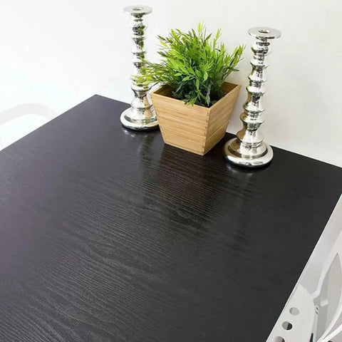 Gotta Have This Slick Black Peel And Stick Vinyl Wrap For Kitchen Countertops And Walls on a table with candles and a potted plant.