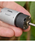 Close-up of Beefy 24mm 370 Planetary Gearbox with full metal gears, shown in hand, DC 12V, 30 RPM, for robotics and hobbyists