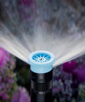 Adjustable Arc Sprinkler Nozzle For Lawns, 6-Foot Radius, 0-360 Degree Spray Pattern, installed among flowers