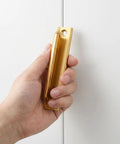 Hand holding Two Piece Aluminum Alloy Drawer Pull Handles 3.5 Inch Low Profile Sash Lift Finger Pulls For Kitchen Cabinets And Dressers, Rust Proof Gold Finish