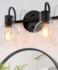 Black 2-Light Vanity Light Fixture With Clear Glass Shades mounted above a round mirror, showcasing a dope modern farmhouse design