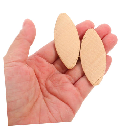 Hand holding two pieces from 100 Pcs Wood Joiner Biscuits Set For Woodworking Projects, Pro Grade Biscuit Plate Joiner Tool.