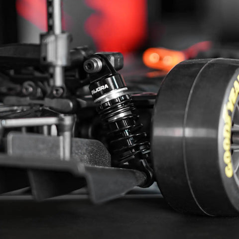 Close-up of 45mm Oil Shocks With Progressive Rate Springs For One Twelfth Losi Nascar RC Upgrades on rear wheel of RC car