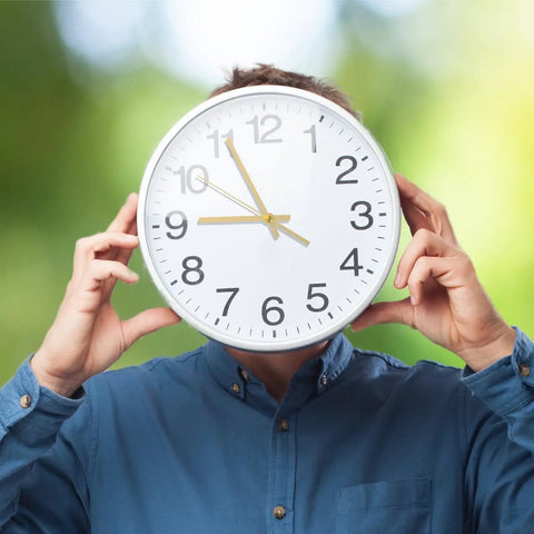 Person holding large clock with gold hands, using Metal Clock Hands Replacement Kit 10 Sets Handy DIY Wall Clock Hands For Home And Kitchen Repair.
