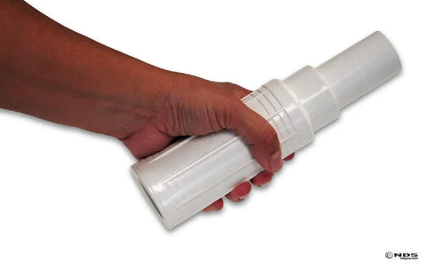 Hand holding Pro Span PVC Expansion Repair Coupling for Cracked or Broken In Ground Pipes 1 Inch IPS Slip X Spigot White Quick Install