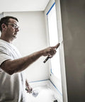 Man applying primer-enhanced spackling from All In One Wall Fix Kit With Primer Enhanced Spackling Compound Putty Knife Sanding Sponge And Self Adhesive Patch For Holes Up To Three Inches In Drywall Plaster Or Painted Surfaces