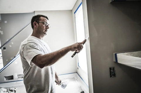 Man applying primer-enhanced spackling from All In One Wall Fix Kit With Primer Enhanced Spackling Compound Putty Knife Sanding Sponge And Self Adhesive Patch For Holes Up To Three Inches In Drywall Plaster Or Painted Surfaces