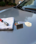 Compact Digital DC Volt And Amp Meter With Hall Effect Sensor Dual LED Display For Cars Boats And Rv on gray car hood with tools.