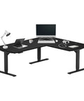 Badass Electric Height Adjustable L Shaped Corner Desk featuring 72 by 60 inch workspace, heavy duty black frame, ebony top, and office accessories.