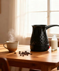 Go To Electric Coffee Maker 600ml Portable Stainless Steel Pot with anti-scald protection on wooden table with cup and milk bottle.