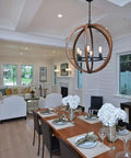Interior view of a dining room featuring a rustic chandelier and a wooden dining table with elegant table settings.
