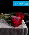 Bouquet of red roses wrapped in Wide 17.5 Inch Clear Cellophane Wrap Roll, 50 Feet Long, 3 Mil Thick, Slick For Gift Wrapping.