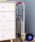 Hella Tough Folding Sack Truck With Solid Rubber Wheels And Rugged Utility Dolly Platform leaning against a drawer unit.