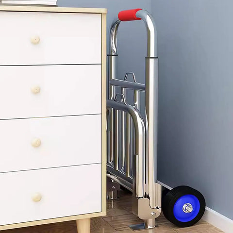 Hella Tough Folding Sack Truck With Solid Rubber Wheels And Rugged Utility Dolly Platform leaning against a drawer unit.