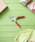 Five Claw Hollow Stainless Steel Snap Fasteners Kit With Pliers And Installation Tool For Quick Do It Yourself Sewing On Shirts Jeans Baby Clothes And Accessories, red-handled pliers with snap parts on green surface
