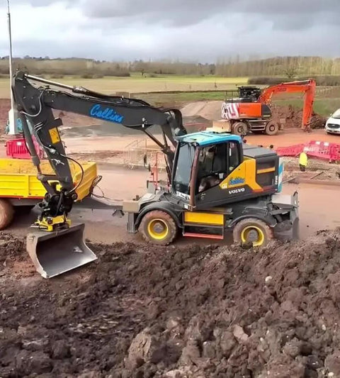 Excavator on construction site with bucket attachment, showcasing versatility of Fast Swap Quick Hitch For Mini Excavators And Backhoes