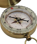 Close-up of the Glow In The Dark Brass Pocket Compass for Kids, open to reveal its luminous dial and brass housing.