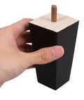4 Pcs Wood Furniture Legs Replacement For Sofa, Coffee Table, Dresser And Cabinet Bed Feet Black Minimalist Style shown in hand view