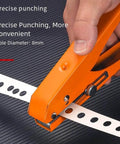 Close-up of orange Pro Grade 15mm Hole Punch Pliers with Fixed Guide punching holes in paper, ergonomic anti-slip grip visible