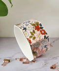 Ceramic Paper Clip Holder With Gold Line Dispenser, floral pink design, holding paper and binder clips on desk.