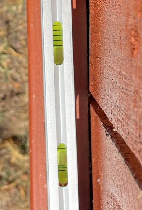 Close-up of Built Tough 12 Inch Magnetic Toolbox Level with Aluminum Frame against wooden surface, showing vials.