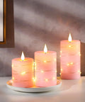 Three Pack Pink Real Wax Flameless Taper Candles With Lifelike Flickering LED Flame And Surrounding Fairy Lights on Plate