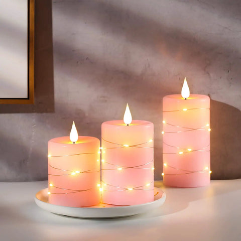 Three Pack Pink Real Wax Flameless Taper Candles With Lifelike Flickering LED Flame And Surrounding Fairy Lights on Plate