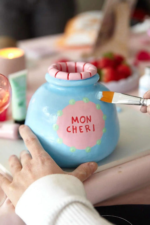 Date Night Special Edition Air Dry Clay Kit For Adults With Tools Paints Brushes Sealant And How To Guides Beginner Friendly DIY Pottery Kit For Home Craft And Relaxing Creative Sessions image showing hand painting a blue clay pot labeled 'Mon Cheri'