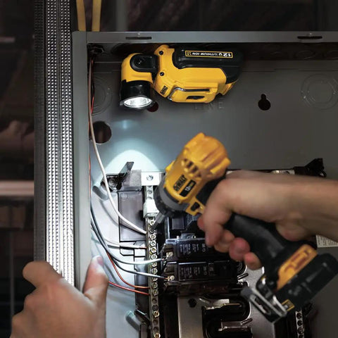 Go To Portable 12V Max LED Work Light With Magnetic Mount And Kickstand illuminating electrical panel, hands holding screwdriver.