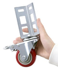 Close-up of a hand holding a Three Inch Caster Wheel for Boltless Shelving Racks, 500 lb load capacity, showing metal bracket and red wheel.