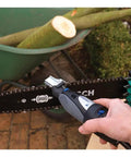 Using the Six Piece Chainsaw Sharpening Attachment Kit For Dremel 1453 Chains on a chainsaw in a garden setting.