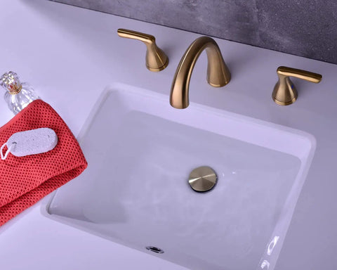 Two-Handle 8-Inch Gold Widespread Bathroom Faucet With Pop-Up Drain on white basin, brushed gold finish, modern design