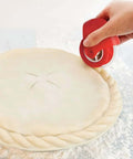 Pastry wheel cutter, red plastic, used to crimp edge of unbaked pie crust.