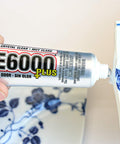 Hand applying Clear Multipurpose Adhesive For DIY Projects With Low Odor Self Leveling And Flexible Bond to broken ceramic vase.