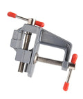 Rock Solid Mini Bench Vise, Clamp On Table Workstation Setup, gray steel with red handles, compact design for woodworking.