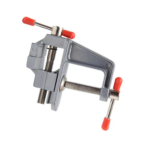 Rock Solid Mini Bench Vise, Clamp On Table Workstation Setup, gray steel with red handles, compact design for woodworking.