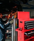 Five Drawer Rolling Tool Chest With Lockable Cabinet On Heavy Duty Wheels For Garage And Workshop Detachable Removable Tool Storage In Cold Rolled Steel Red And Black Finish is open beside a mechanic working under a car