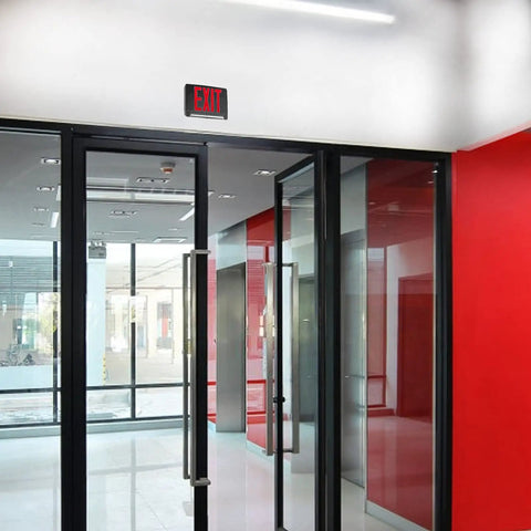 Ultra Bright Battery-Backed LED Exit Sign With Indoor Emergency Lighting And Chevron Arrow, installed above glass doors.