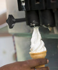 Plastic Ice Cream Maker Nut Fastener Replacement Part in use on machine, dispensing soft serve into a cone