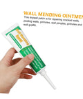 Hand holding a tube of Two Set Wall Mending Repair Cream For Cracks Graffiti And Stains Easy To Apply Crack Paste With Scraper Quick Fix For Holes Peeling Walls And Maintenance Durable White Latex Repair Paste.