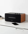 Dope Desktop Bluetooth Speaker Set With 70W RMS, Wooden Enclosure For Rich Warm Sound, on a desk next to a smartphone