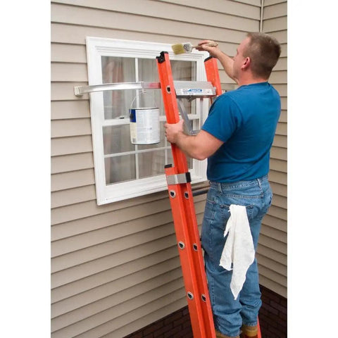 Person painting a window using a Heavy Duty Ladder Stabilizer for 45 Inch Ladders with Quickclick Lock, anti slip feet visible