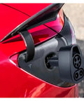 Close-up of Heavy Duty Ev Charging Adapter For Tesla Model 3 Y S X CCS1 Combo DC To AC Power Converter attached to red car.