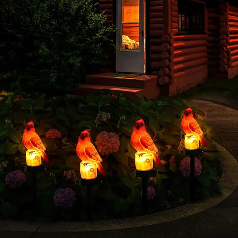 Four red bird solar light garden stake figurines glowing at night in a backyard, Red Bird Solar Light Garden Stake Figurine For Outdoor Yard Decor Memorial Glow At Night Patio Ornament Gift For Mom And Grandma.