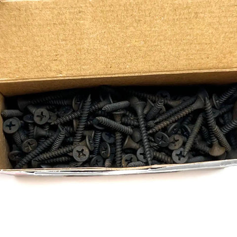 Pro Grade Drywall Screws For Light Gauge Steel Studs Size Six By One And A Quarter Inch in a cardboard box, showing fine thread and bugle heads.