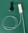 Hassle Free Grab And Go Portable Usb Oil Extractor Pump With Suction Syringe Flexible Hose on green surface.
