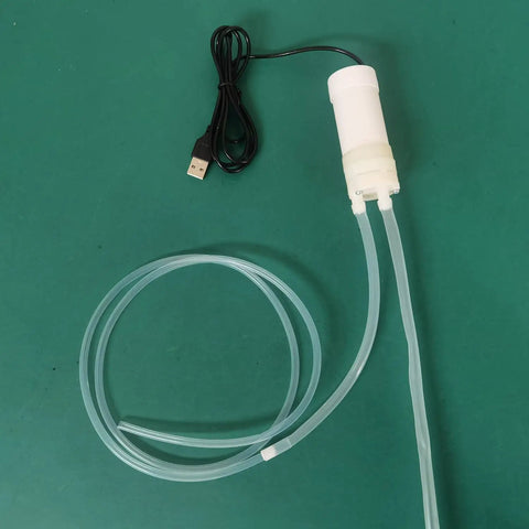 Hassle Free Grab And Go Portable Usb Oil Extractor Pump With Suction Syringe Flexible Hose on green surface.