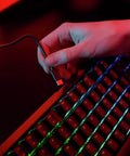 Close-up of hand connecting USB cable to Slick Wireless Mechanical Gaming Keyboard Triple Mode Bluetooth And 2.4GHz Connectivity Ultra Low Latency.
