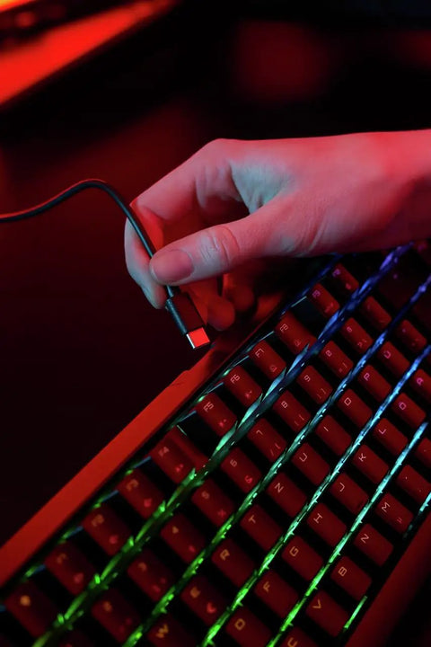 Close-up of hand connecting USB cable to Slick Wireless Mechanical Gaming Keyboard Triple Mode Bluetooth And 2.4GHz Connectivity Ultra Low Latency.