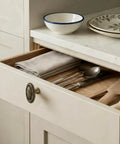 Open drawer with Antique Brass Floral Carved Cabinet Knob Set for Dresser, showing cutlery and linen inside